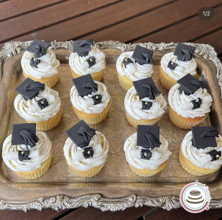 Cupcakes with white frosting and black graduation caps