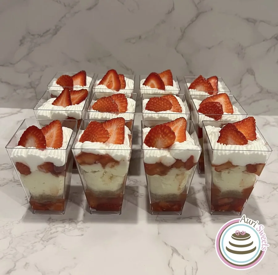 Individual strawberry dessert cups with layers of cream and cake